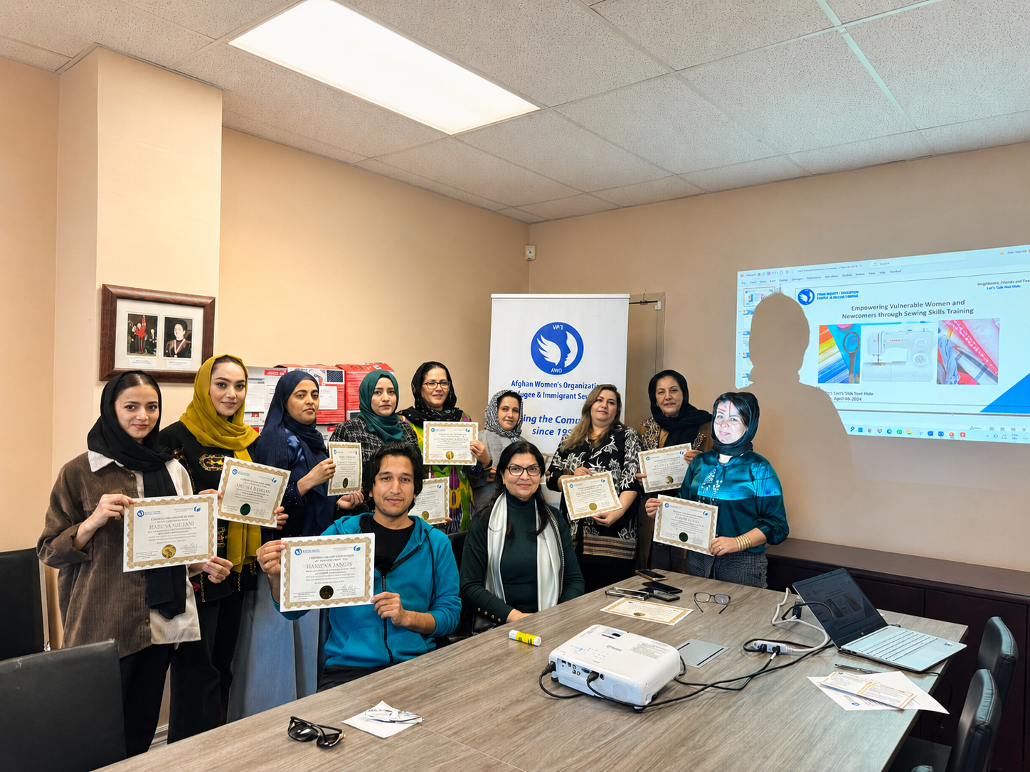 Participants celebrating completion of sewing skills training with their certificates